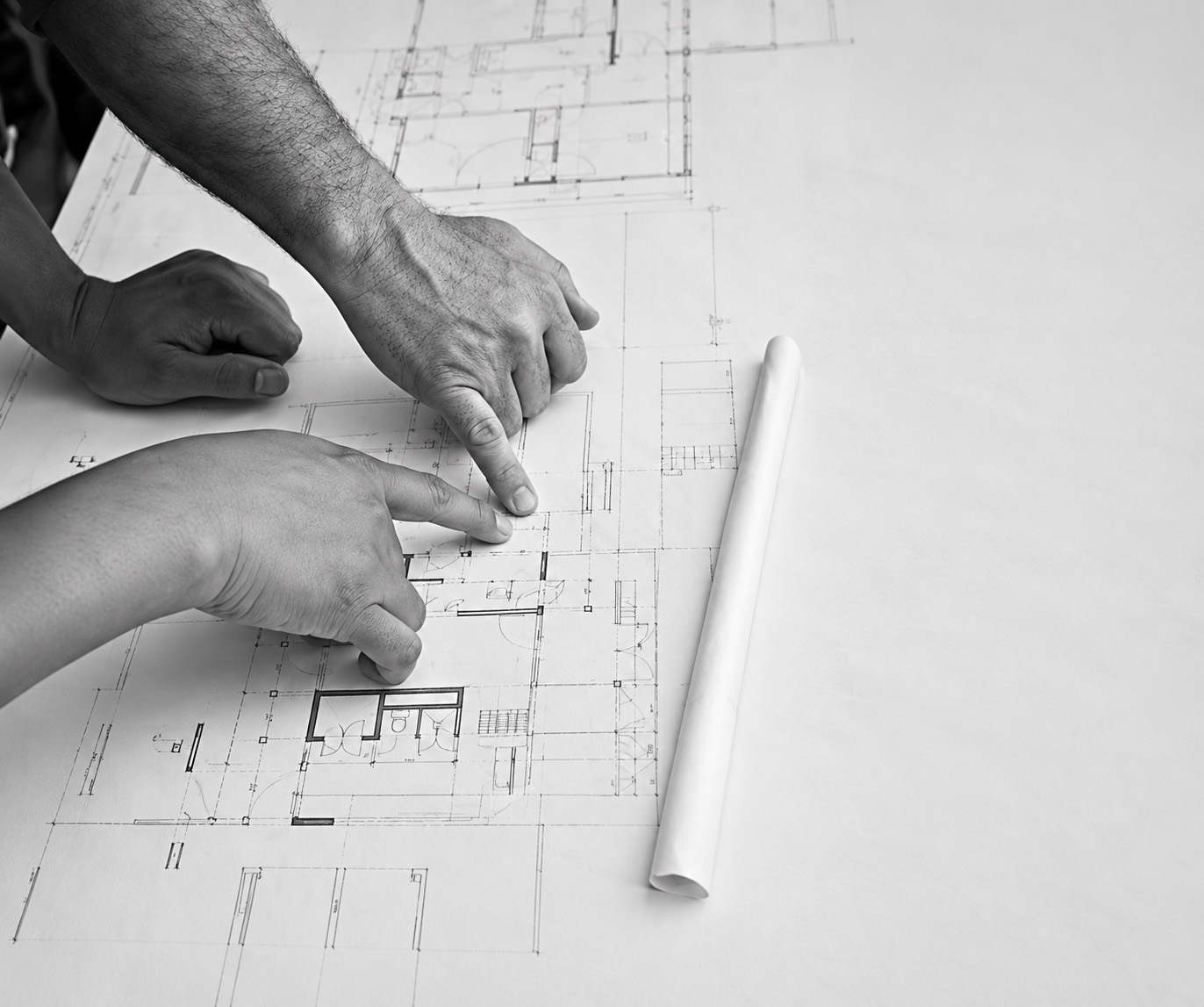 Two JAC Construction team members reviewing architectural plans